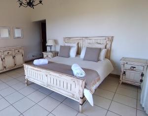 a bedroom with a large white bed with two pillows at Vila Sol - Self Catering in Vila Praia Do Bilene