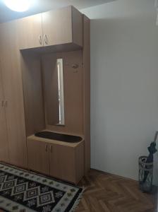 a kitchen with wooden cabinets and a mirror at Sokobanja Apartmani in Soko Banja