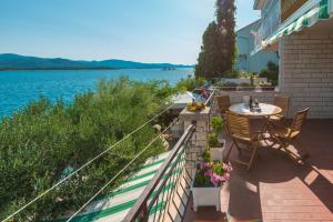 a patio with a table and chairs next to the water at Bace Apartments in Klek