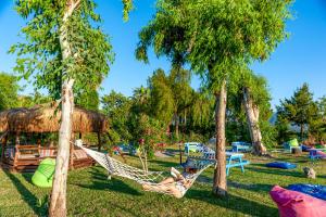 a man in a hammock in a park with trees at Portakal Hotel Dalyan in Dalyan