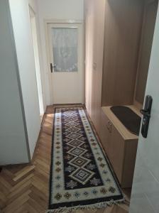 un pasillo con una alfombra en el suelo junto a una puerta en Sokobanja Apartmani en Soko Banja