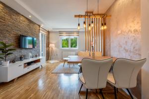 a dining room with a table and chairs and a brick wall at Carpe Diem in Zlatibor