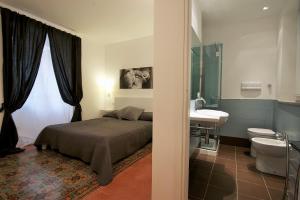 a bedroom with a bed and a bathroom with a sink at Via Roma 10 in Trapani