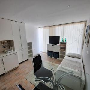a living room with a glass table and a chair at Apartment Luka in Portorož