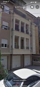 a white car parked in front of a house at Ana's Apartment in Belgrade