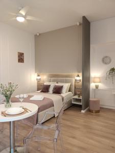 1 dormitorio con 1 cama, mesa y sillas en MyFive Apartments Kraków, en Cracovia