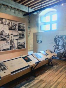 a room with a table with pictures on the wall at Gite la petite pataudiere in Le Guédéniau