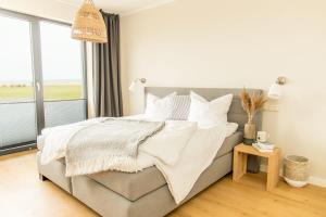 a bedroom with a bed and a large window at FerienDüne "Riedensee" in Kühlungsborn