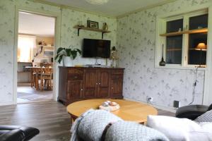 a living room with a table and a tv at Boende nära Romme Alpin och andra friluftsaktiviteter i Dalarna in Smedjebacken