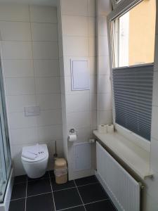 a white bathroom with a toilet and a window at Hotel Domke Haus an der See in Bansin