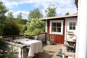 a patio with a table and chairs on a deck at Boende nära Romme Alpin och andra friluftsaktiviteter i Dalarna in Smedjebacken