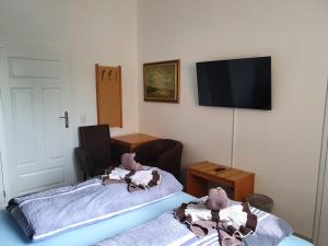 a room with two beds and a flat screen tv at Hotel Domke Haus an der See in Bansin