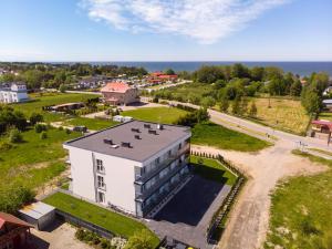 an aerial view of a building with the ocean in the background at Piaski Bałtyku in Gąski