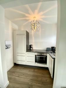 a kitchen with white cabinets and a chandelier at Willinger Perle in Willingen