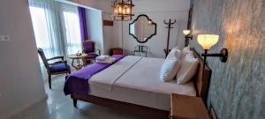um quarto de hotel com uma cama grande e um espelho em Mare Casia Bozcaada Otel em Bozcaada