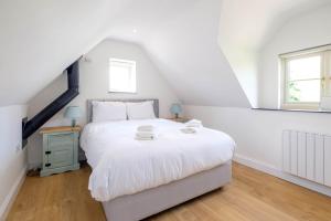 sypialnia z białym łóżkiem i oknem w obiekcie Foxes Lodge w mieście Aldringham