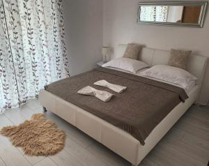 a bedroom with a bed with two towels on it at Apartments Neda in Primošten