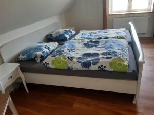 a bed with blue and white sheets and pillows at Ferienwohnung Wald und Weitblick in Dreschvitz