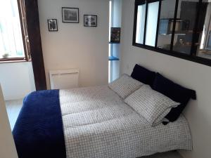 Dormitorio pequeño con cama y espejo en Appartement Haute Ville meublé avec cour privative, en Granville