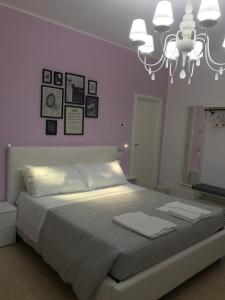 um quarto com uma grande cama branca e um lustre em Residenza Aurea em Offida
