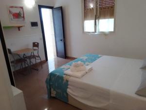 a bedroom with a bed with towels on it at Camera Noemi in Torre Lapillo
