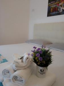 a bouquet of flowers and a towel on a table at Camera Noemi in Torre Lapillo