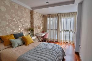 Schlafzimmer mit einem Bett, einem Schreibtisch und einem Fenster in der Unterkunft Apartamento Plaza España in Saragossa