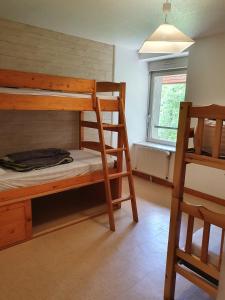 a bedroom with two bunk beds and a window at Gîte du Moulin in Les Planches-près-Arbois