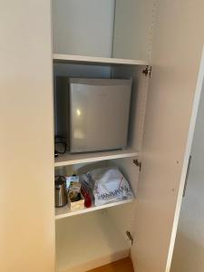 einen Schrank in einer Küche mit Mikrowelle in der Unterkunft Werners Doppelzimmer in Insul