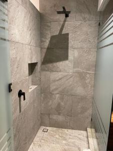 a bathroom with a shower with a stone wall at Hotel Oxú Solo adultos in Valle de Bravo