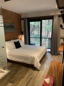 - une chambre avec un lit et une grande fenêtre dans l'établissement Hotel Oxú Solo adultos, à Valle de Bravo