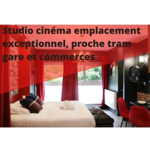 a room with two beds and a red curtain at R'Studio Ciné Salle 2 Hypercentre Grenoble in Grenoble