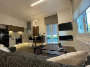 a living room with a couch and a table at Lf Suites - Irene in Thiva