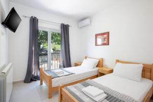 two beds in a room with a window at Guest house Vila Vedesa in Kotor