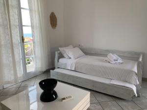 a bedroom with two beds and a table and a window at villa of the god in Skala