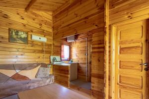 a log cabin with a desk and a bed in it at Domki Nad Potokiem in Polańczyk