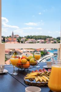 a table with a plate of food and glasses of orange juice at Apartment Darka 1 in Sumartin