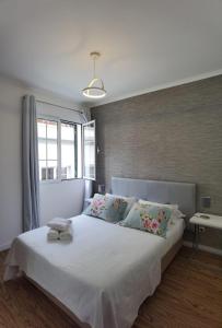 Un dormitorio con una gran cama blanca con almohadas. en Old City Apartment, en Funchal