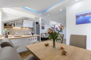 a kitchen and dining room with a wooden table with flowers at Apartment Darka 1 in Sumartin