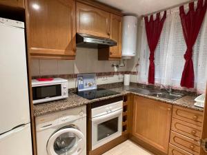 a small kitchen with a washing machine and a microwave at ACAPULCO III MARINA DÓR in Oropesa del Mar