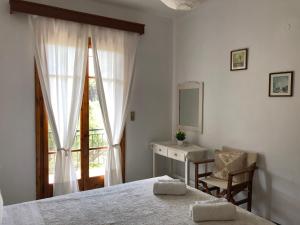 a bedroom with a bed and a desk and a window at Apelati in Keri