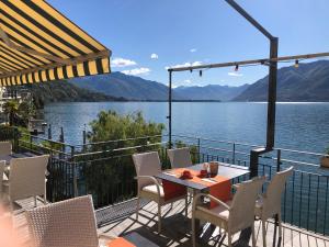 un tavolo e sedie su un balcone con vista sul lago di Art Hotel Ristorante Posta Al Lago a Ronco sopra Ascona