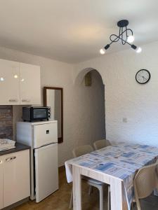 eine Küche mit einem Tisch und einem Kühlschrank in der Unterkunft Villa Gromaca in Omišalj