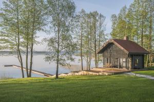 a cabin on a dock next to a body of water at Sodyba Voverė in Inturkė