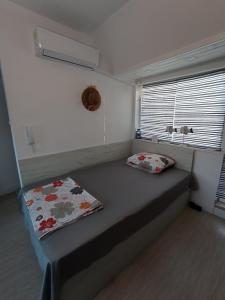 uma cama num pequeno quarto com uma janela em Studio San Stefano em Burgas