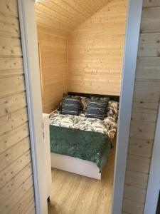 a small room with a bed in a tiny house at Domki Rozewie Holliday in Rozewie