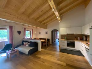 a kitchen and living room with a couch and a table at Trixlhof in Sankt Ulrich am Pillersee