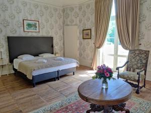 a bedroom with a bed and a table and a chair at Château de Vallagon in Bourré