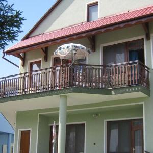 佐洛卡羅斯的住宿－Kispál Apartmanház，房屋设有带遮阳伞的阳台