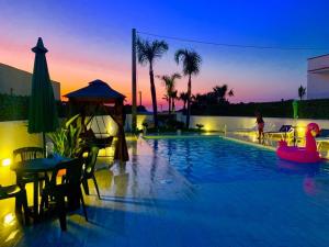 a pool with a table and chairs and a person in a tub at Casa vacanze Misilla in Marsala +6 photos